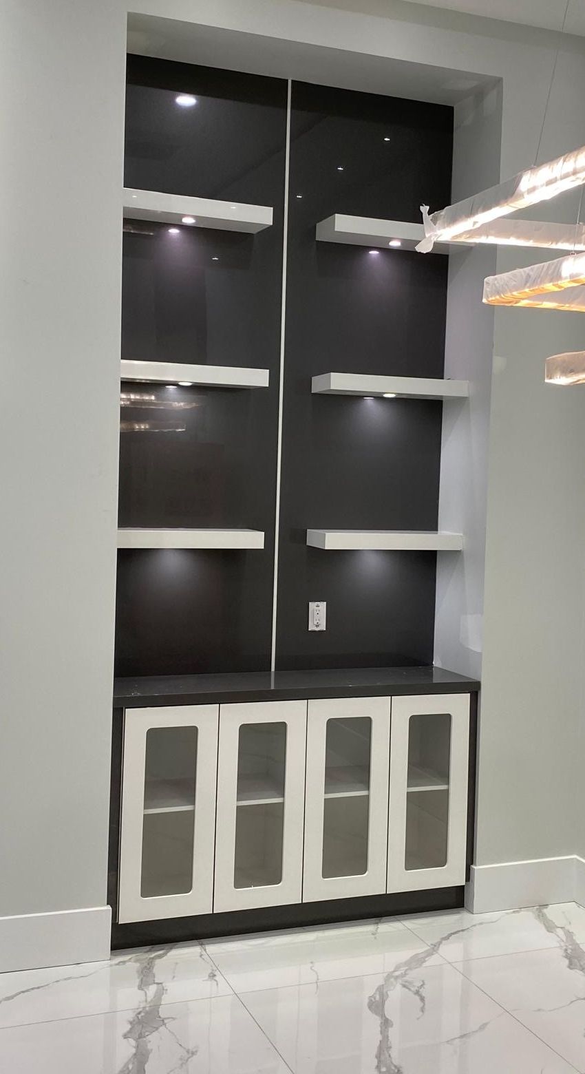 Recessed display unit with lit shelves and glass-front doors