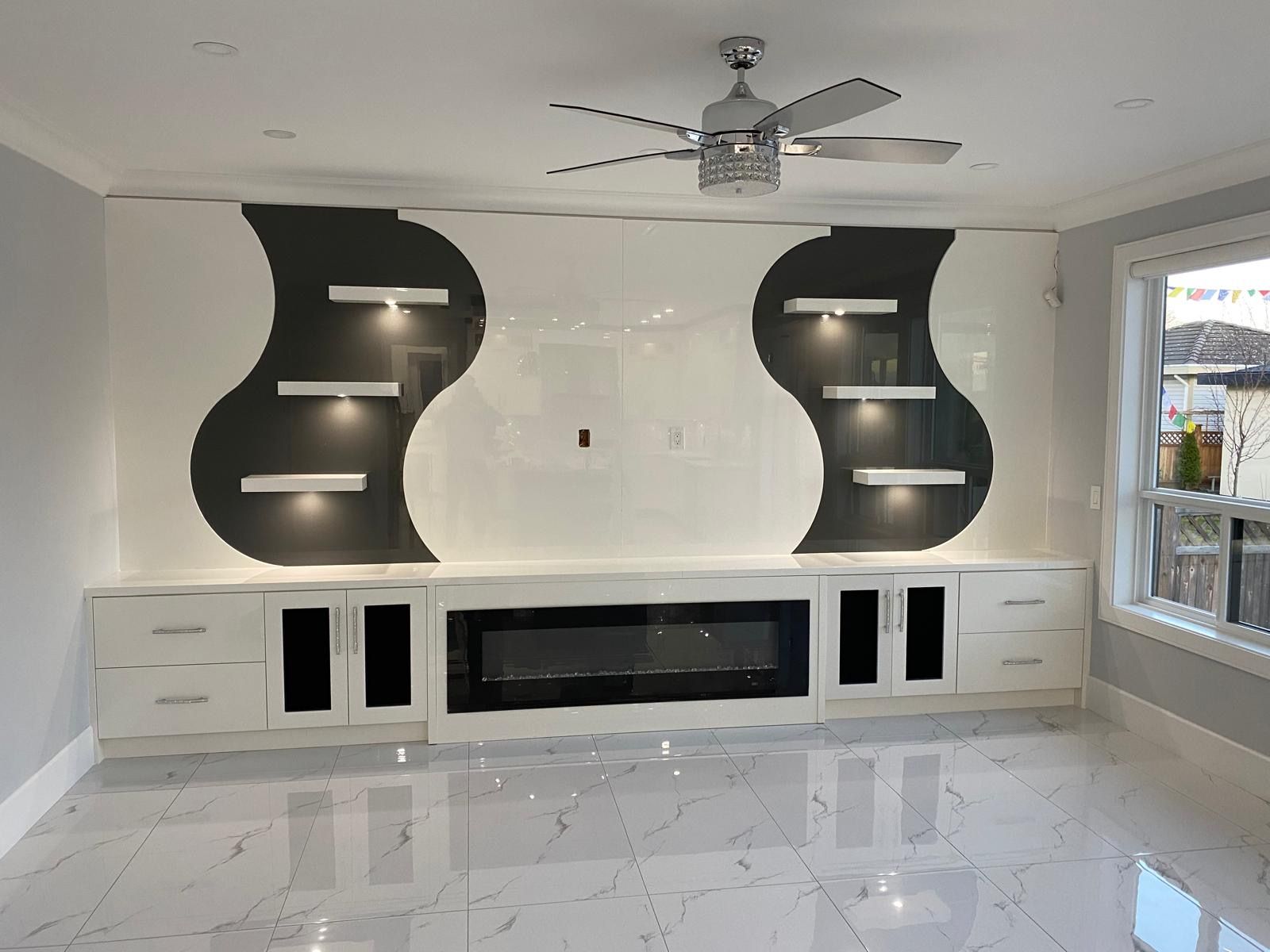 Feature wall with curved black inset panels, lit floating shelves and a linear fireplace